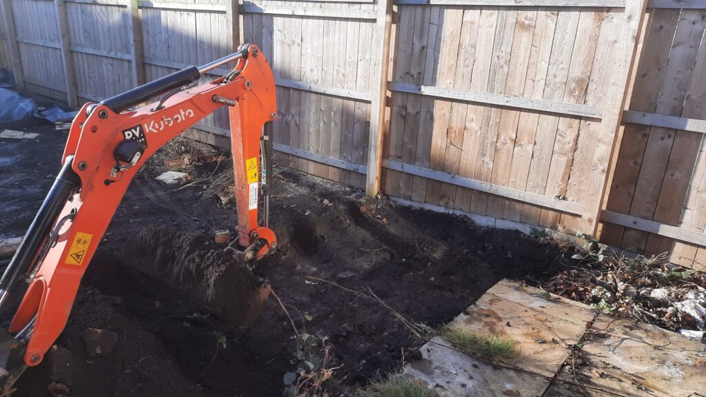 Mini digger excavating in a garden