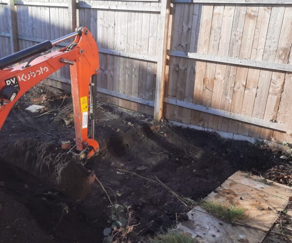 Mini digger excavating in a garden